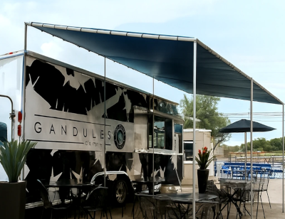 Gandules food truck with outdoor seating area on a clear day