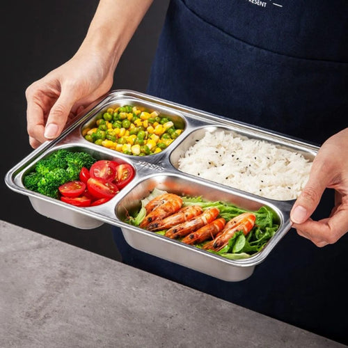 Person holding a stainless steel lunch box with compartments of food including vegetables and shrimp.